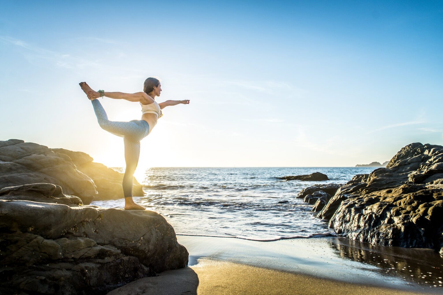 woman doing yoga on beach