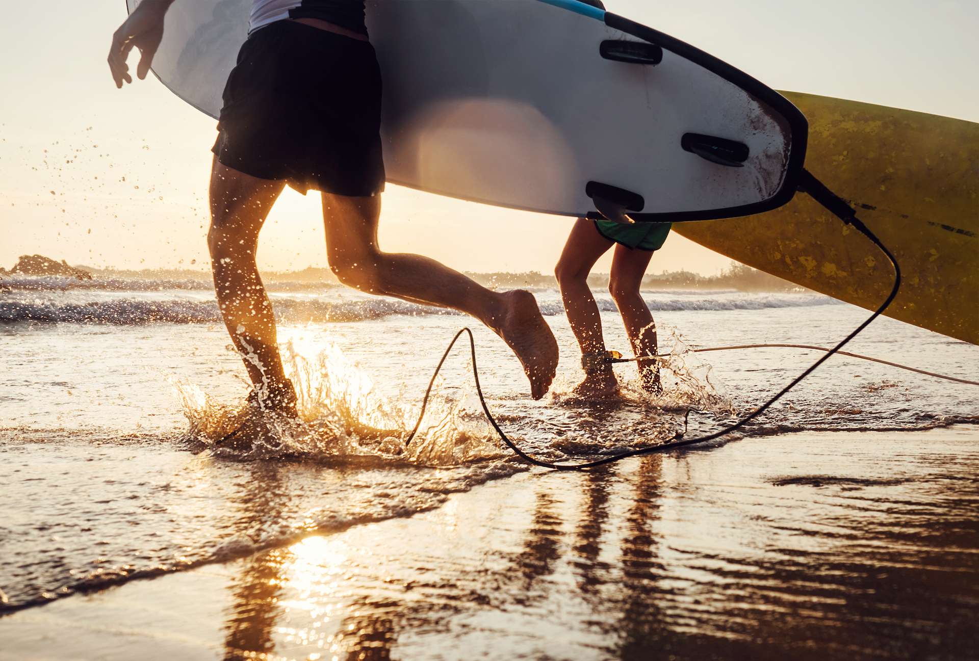 Surfers running on ocean